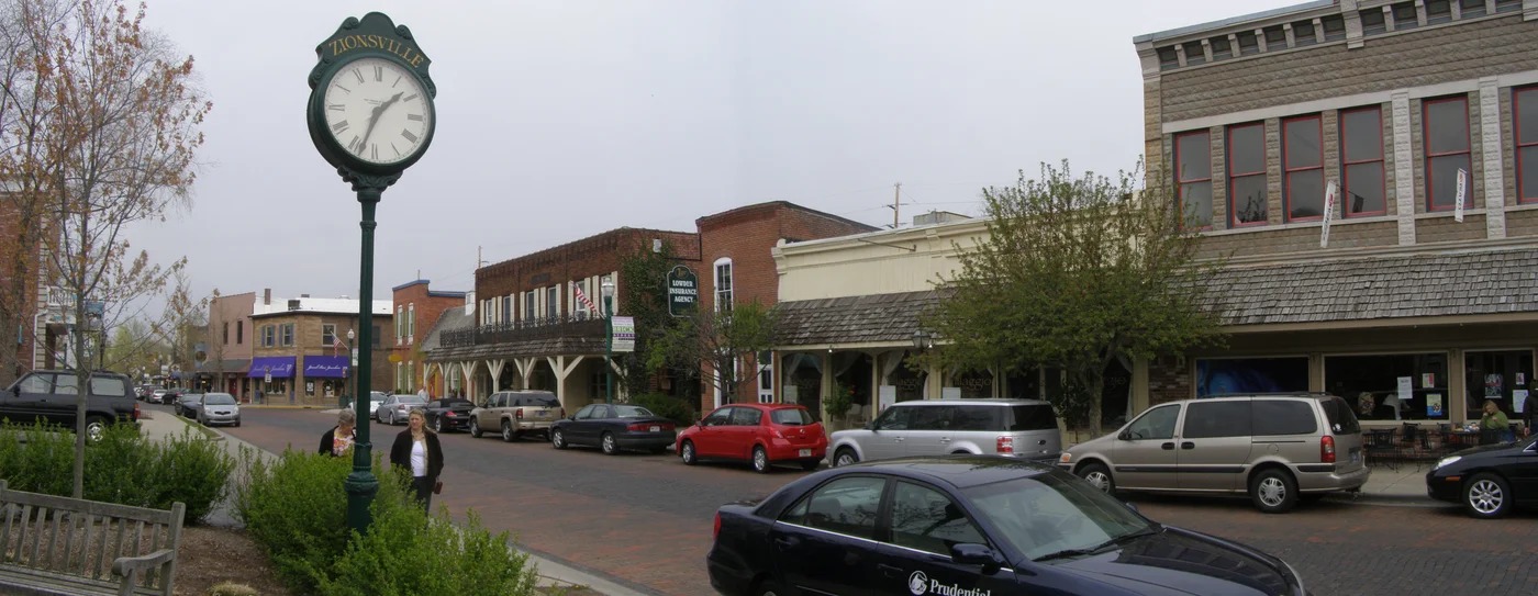 Street clock and storefronts along brick Main Street in Zionsville